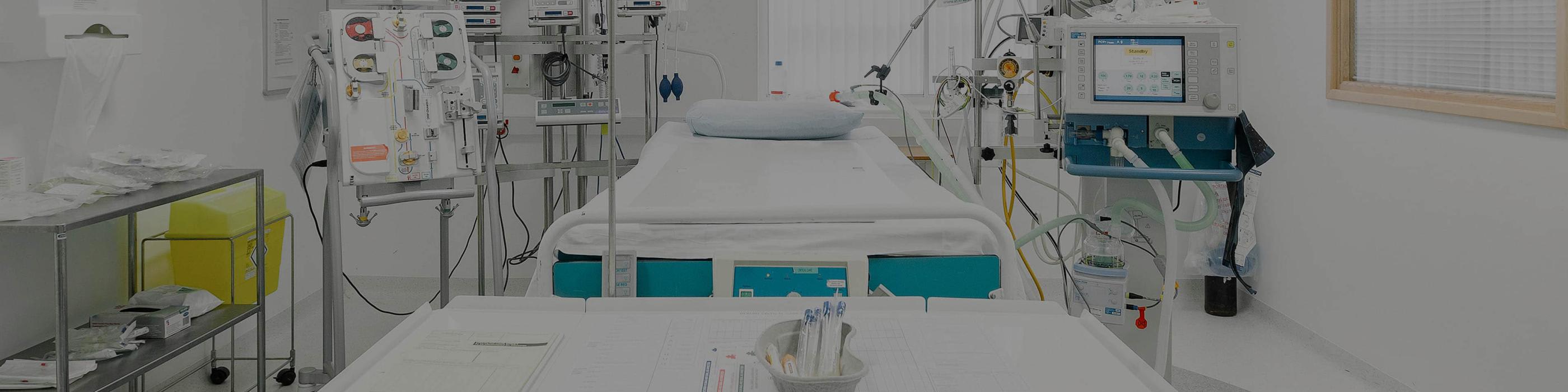 The image depicts an Intensive Care Unit (ICU) within a hospital setting. 